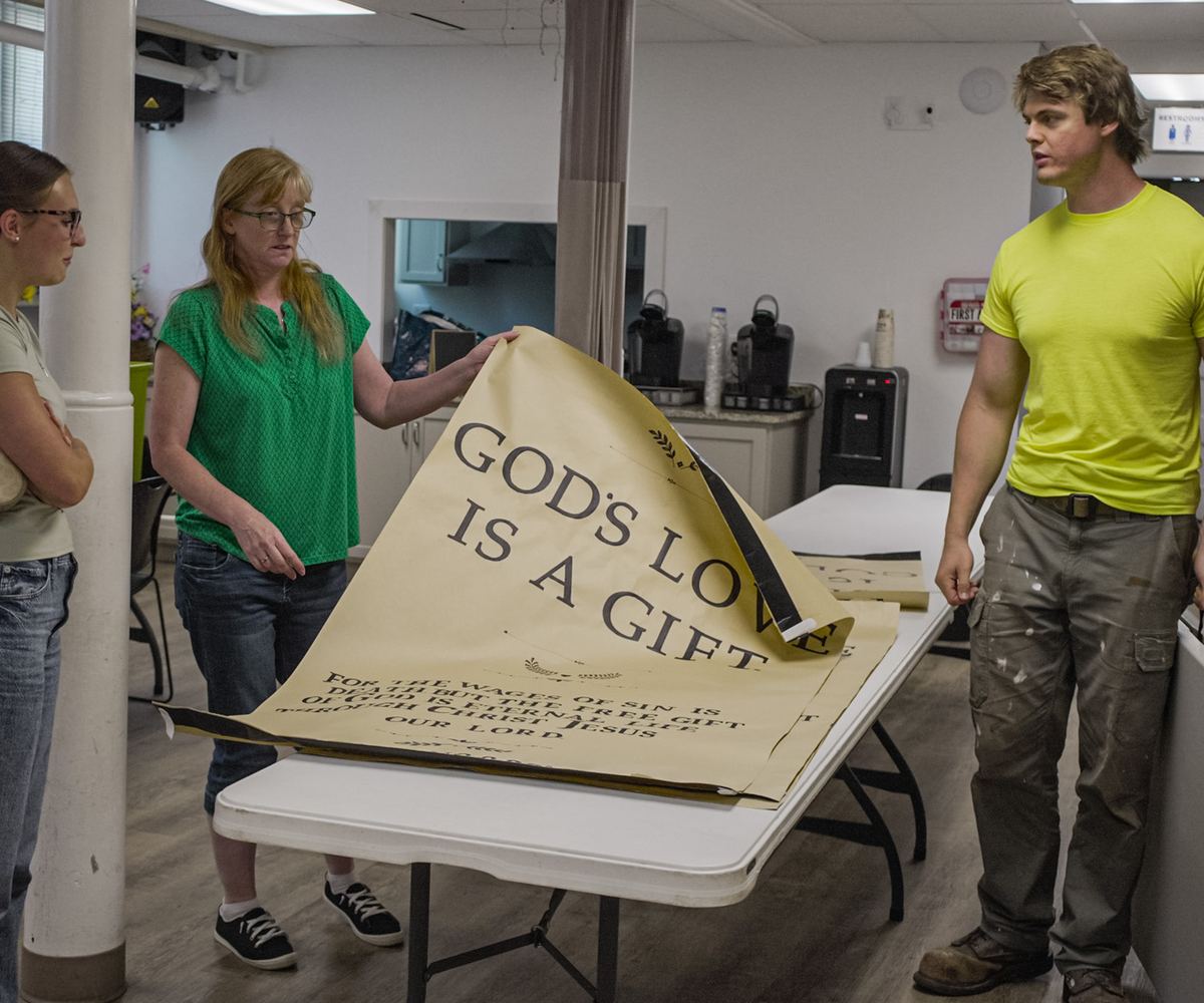 LifeChurch volunteers unrolling a “God’s Love Is a Gift” banner