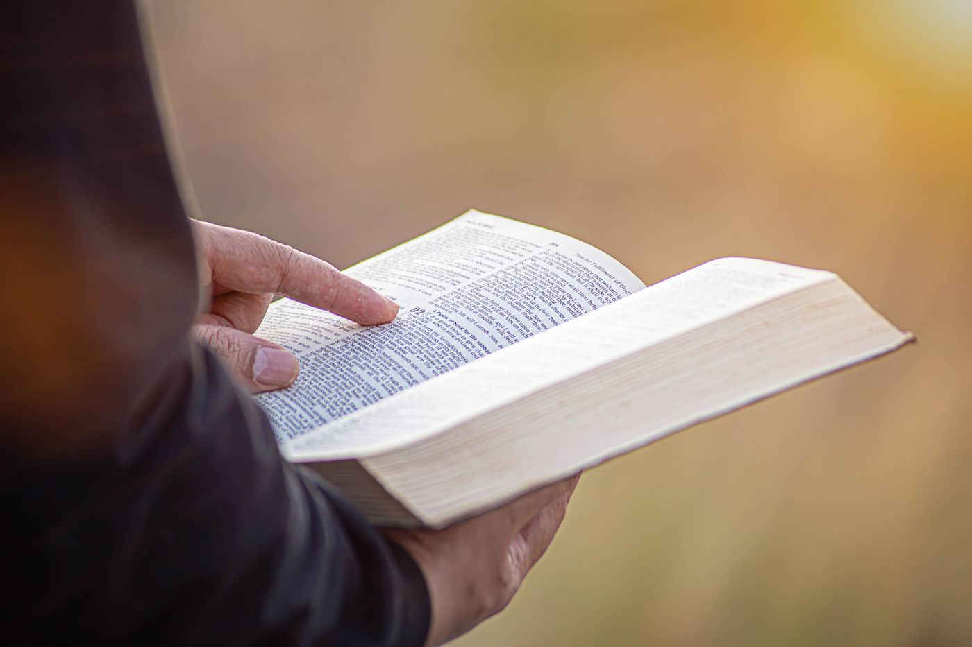 An open Bible held in hand
